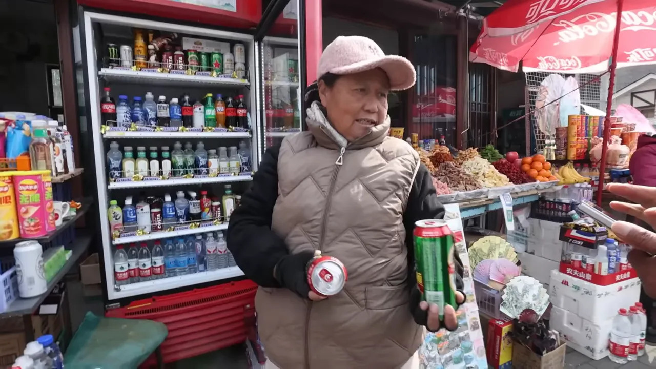 Vendor selling drinks at a street shop with customer holding a can