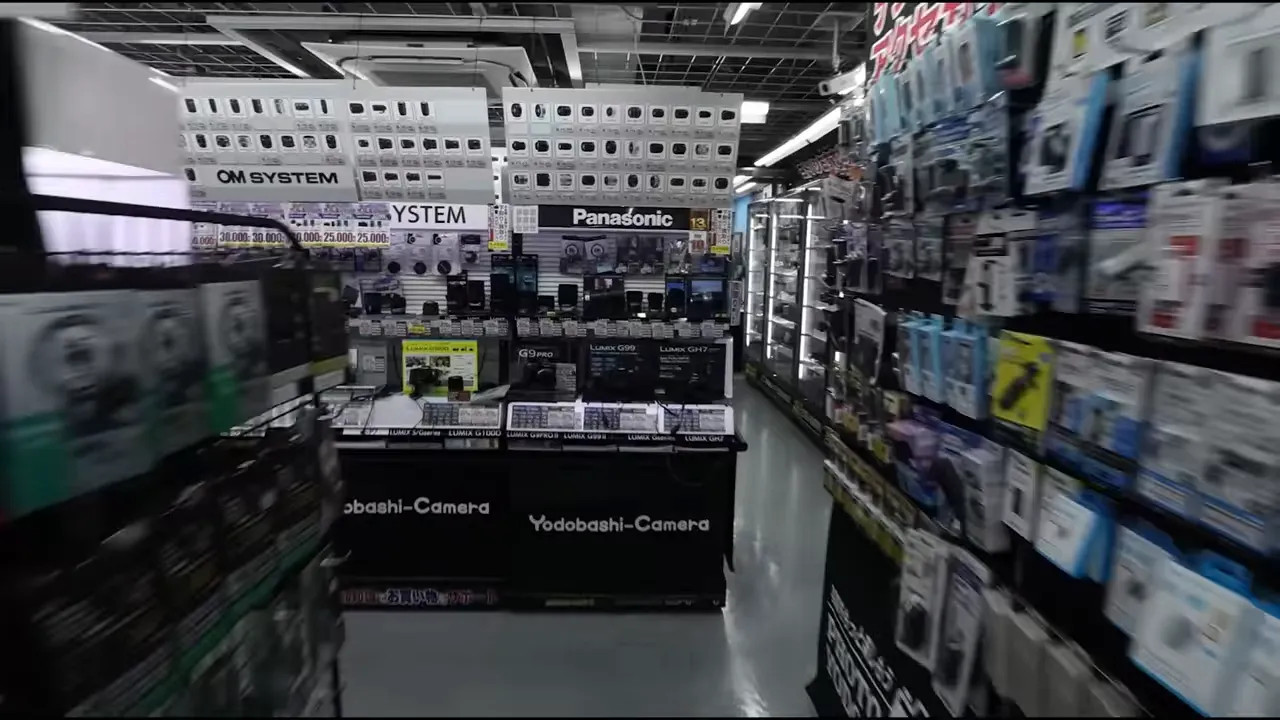 Clear view down a Yodabashi Camera aisle toward electronics counters