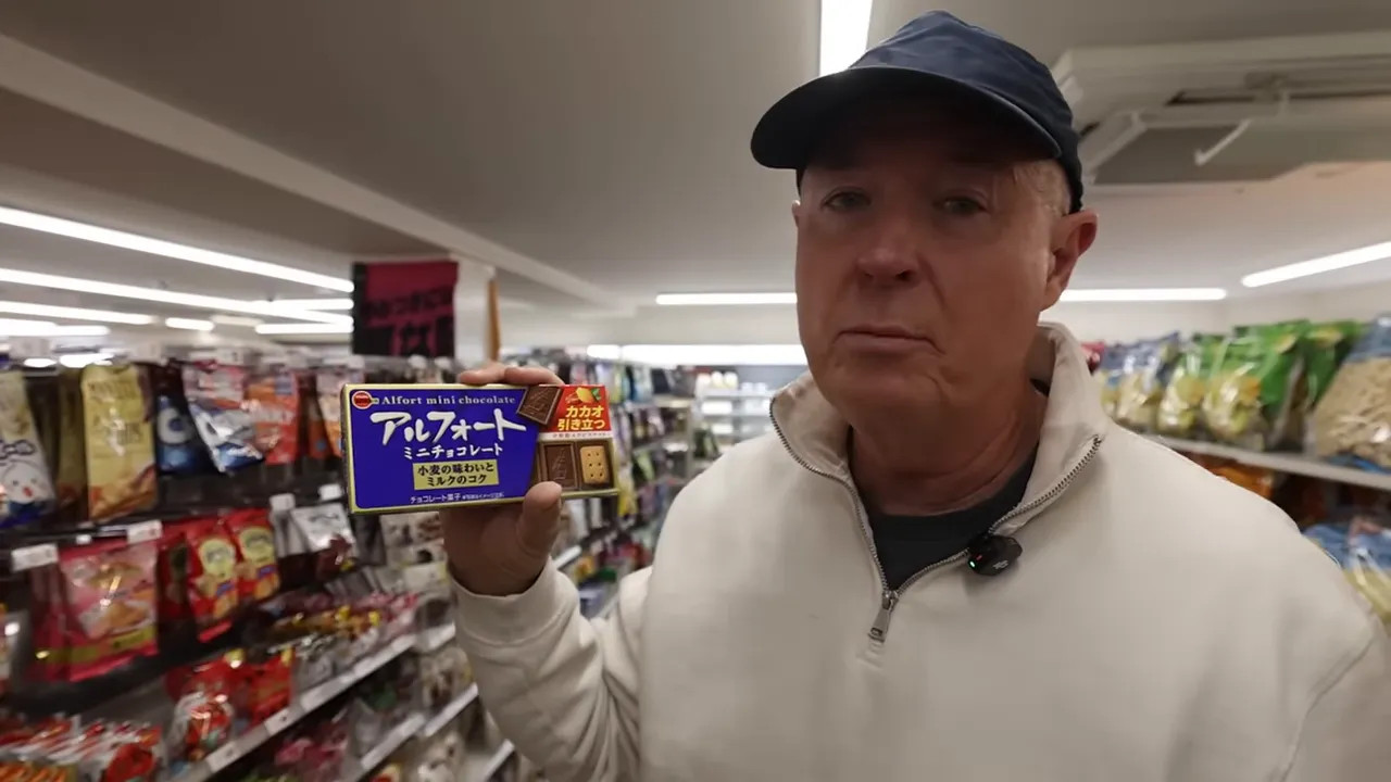 Man holding a mini chocolate snack box in a Japanese convenience store