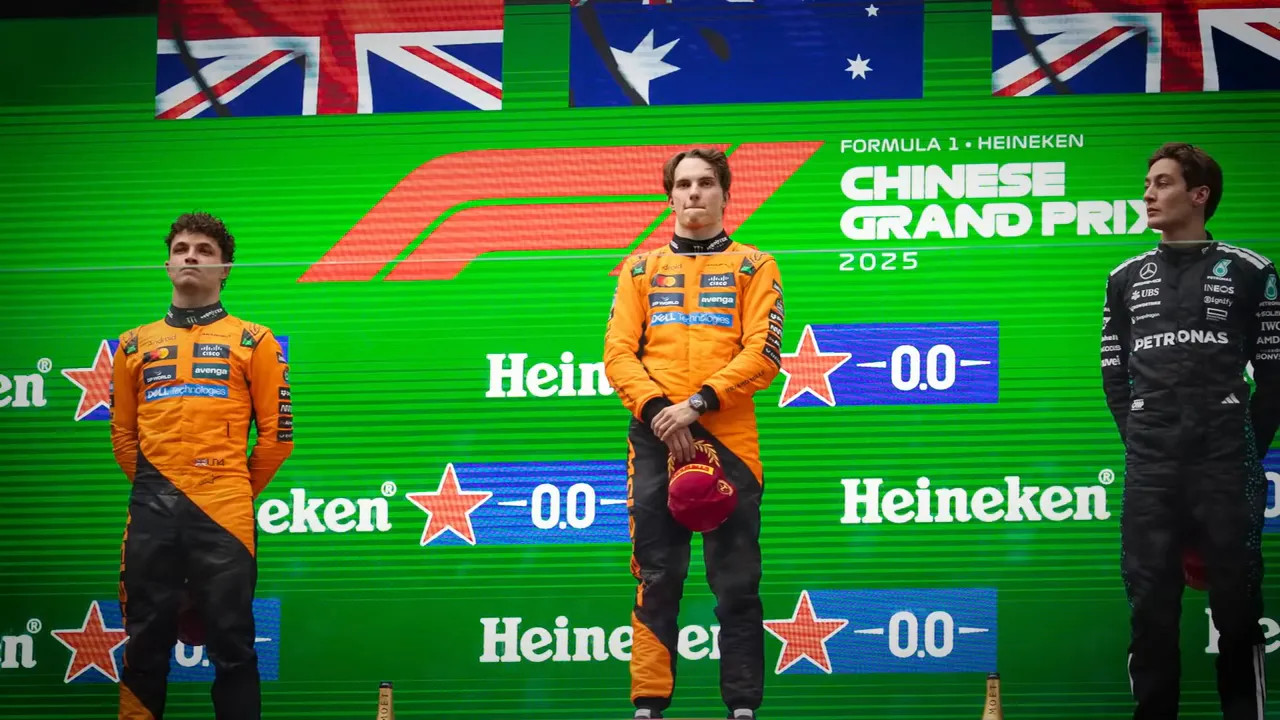Chinese Grand Prix 2025 podium with two orange-suited drivers and a rival in black against a green Heineken backdrop