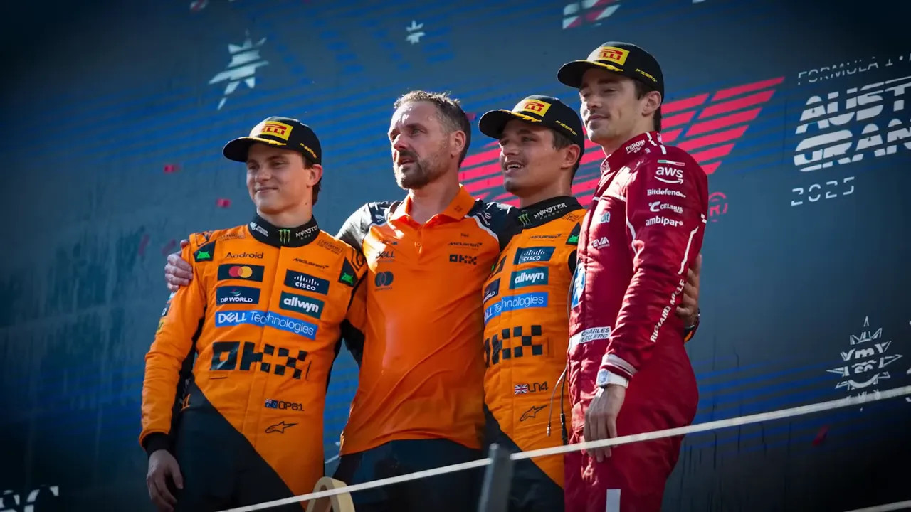 Three Formula 1 drivers on a podium with team colours and sponsor backdrop, celebrating after a race.