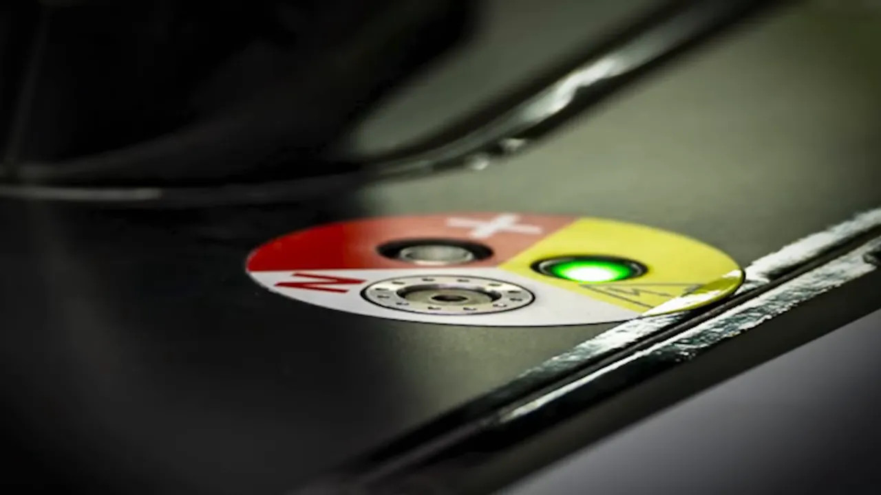 Close-up of a car body panel showing a circular clutch disengagement switch area with colored markings