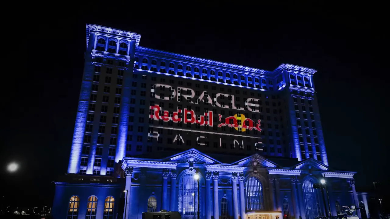 Michigan Central Station facade illuminated at night with a large Oracle Red Bull Racing projection.