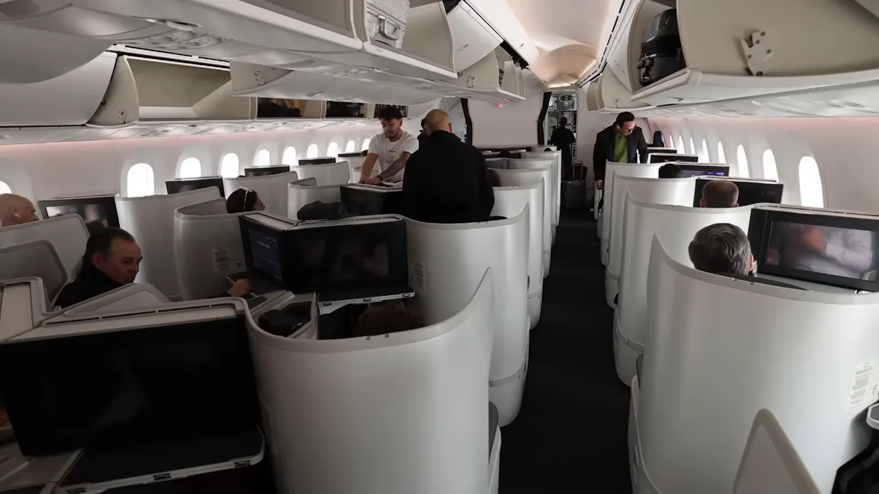 AeroMexico 787-9 business class cabin showing staggered fully-flat suite seats with privacy shells and in-flight entertainment screens.