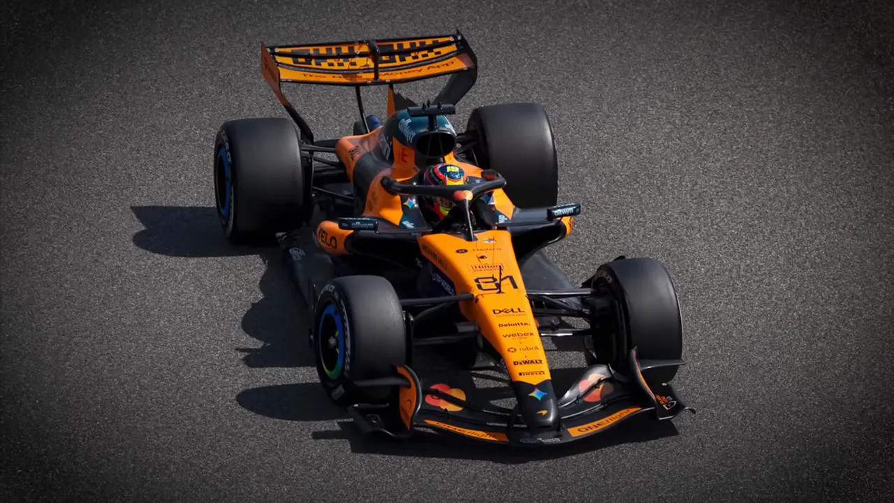 Top-down view of McLaren 2026 F1 car showing papaya livery and cockpit detail on the asphalt