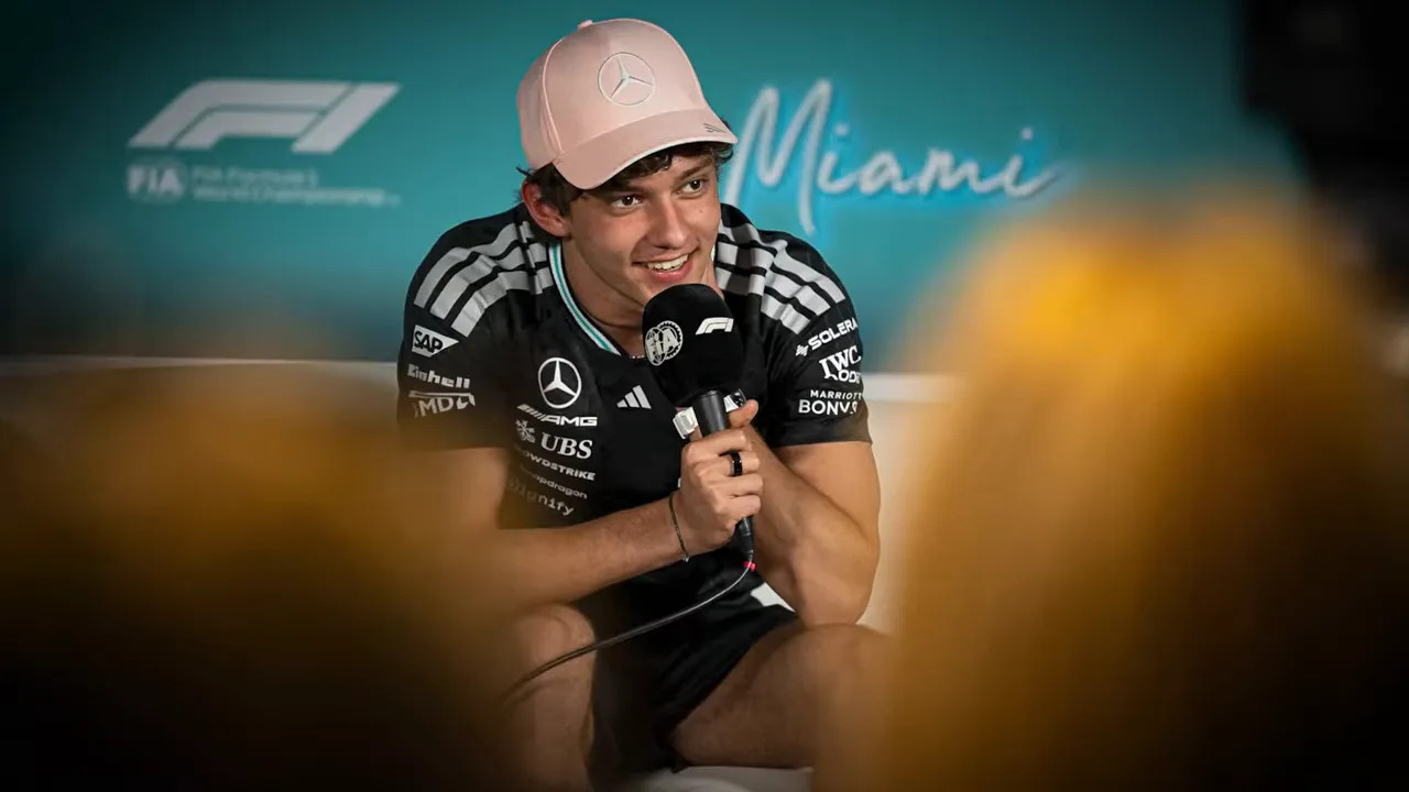 Kimi Antonelli speaking with a microphone at the FIA media backdrop in Miami