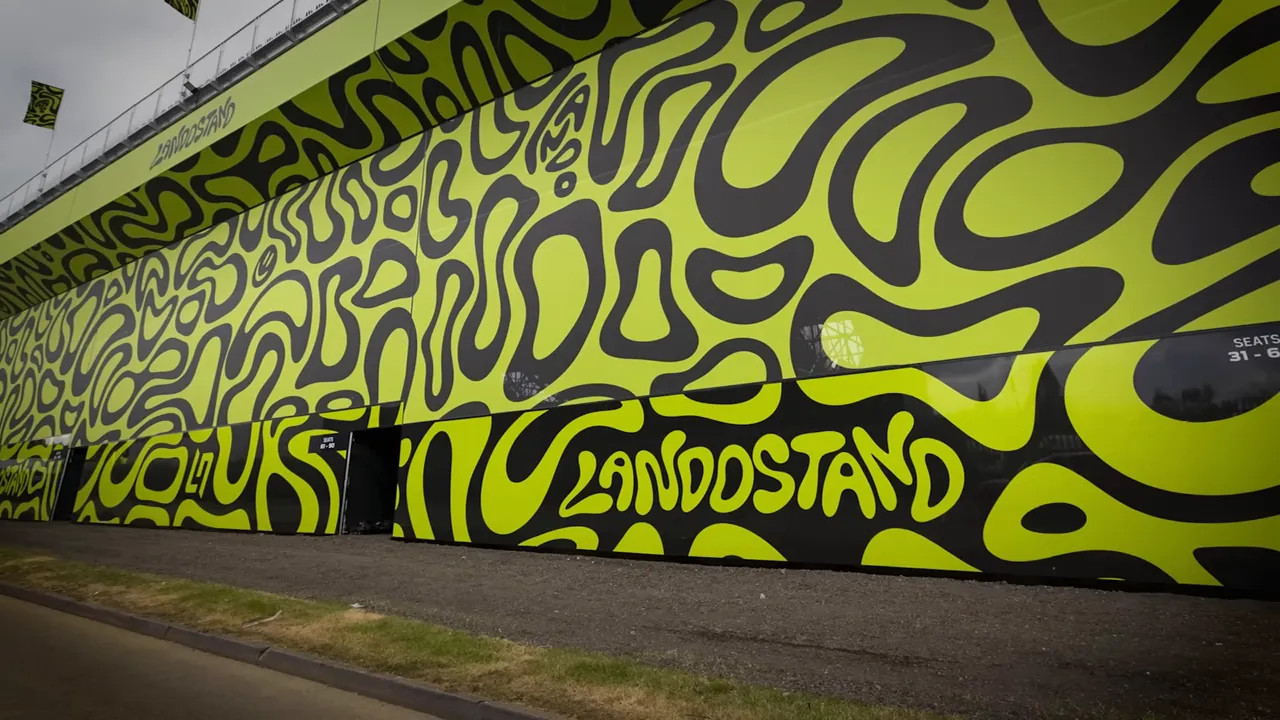 Exterior wall painted in yellow and black pattern with Lando Stand written across it