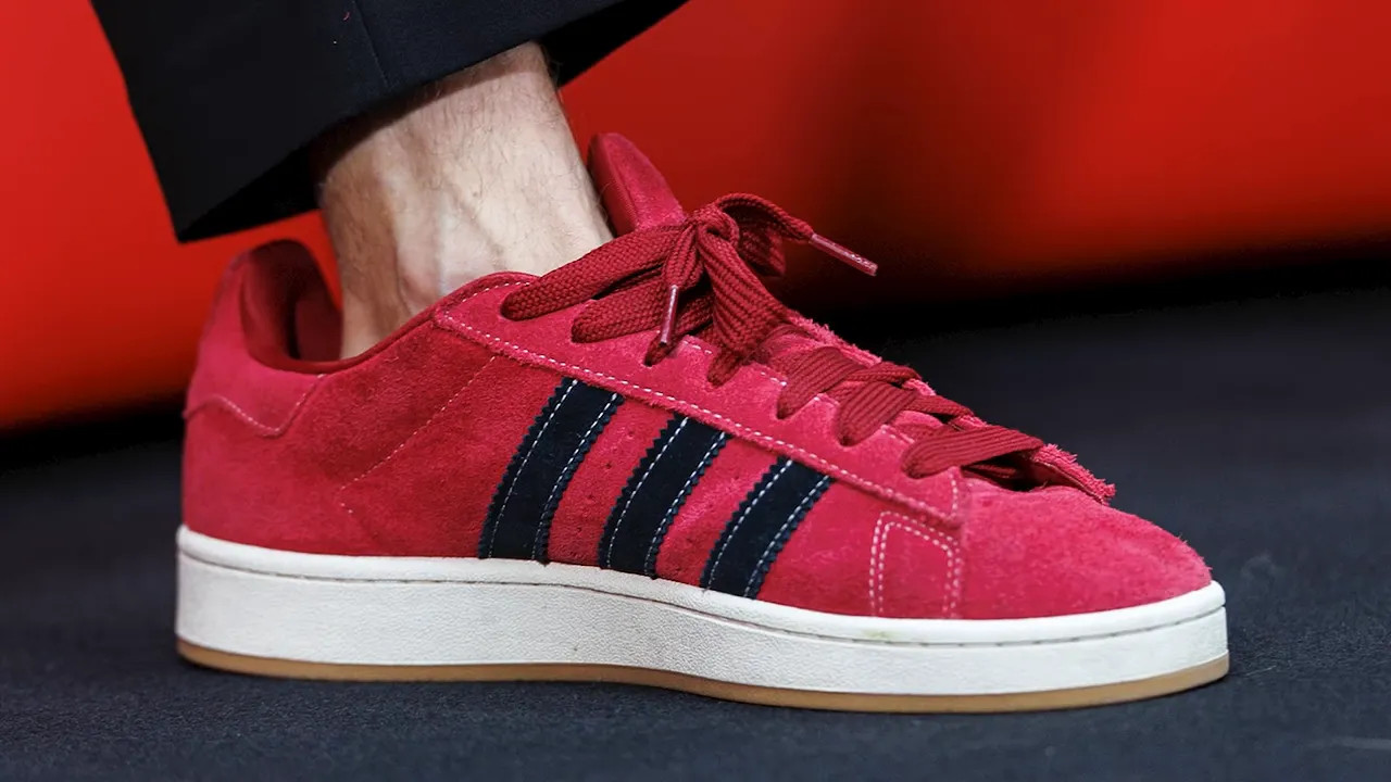 Close-up of red trainers with black stripes and visible space around the ankle