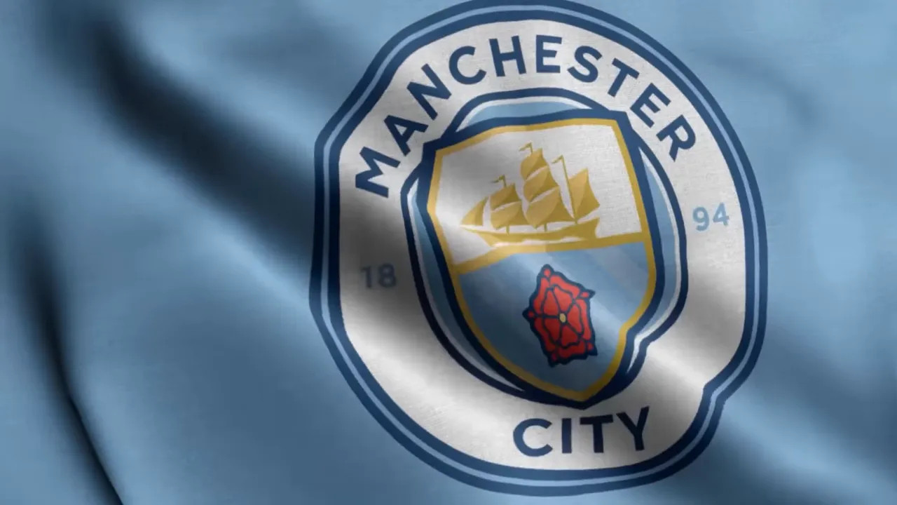 Close-up of Manchester City crest on light blue fabric