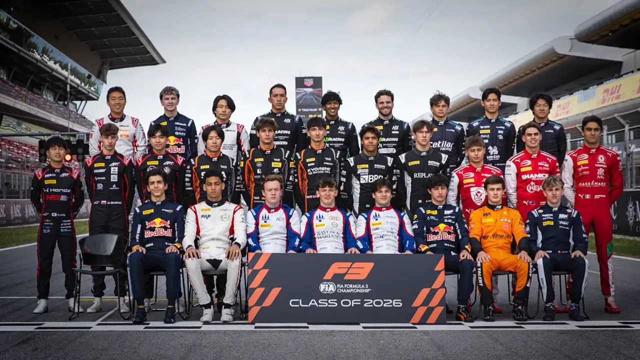 group portrait of Formula 2 drivers posing on track behind class of 2025 sign