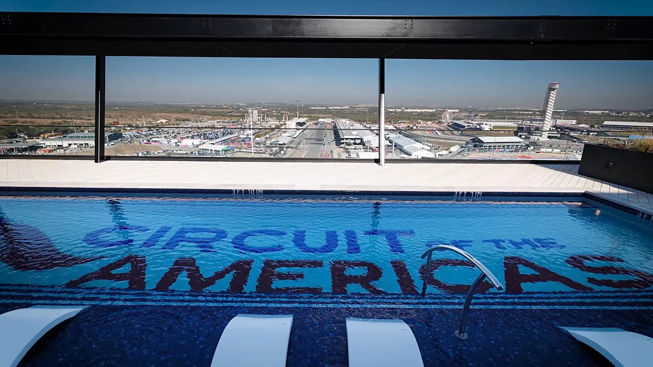 Rooftop swimming pool with Circuit of the Americas lettering and a panoramic view of the track