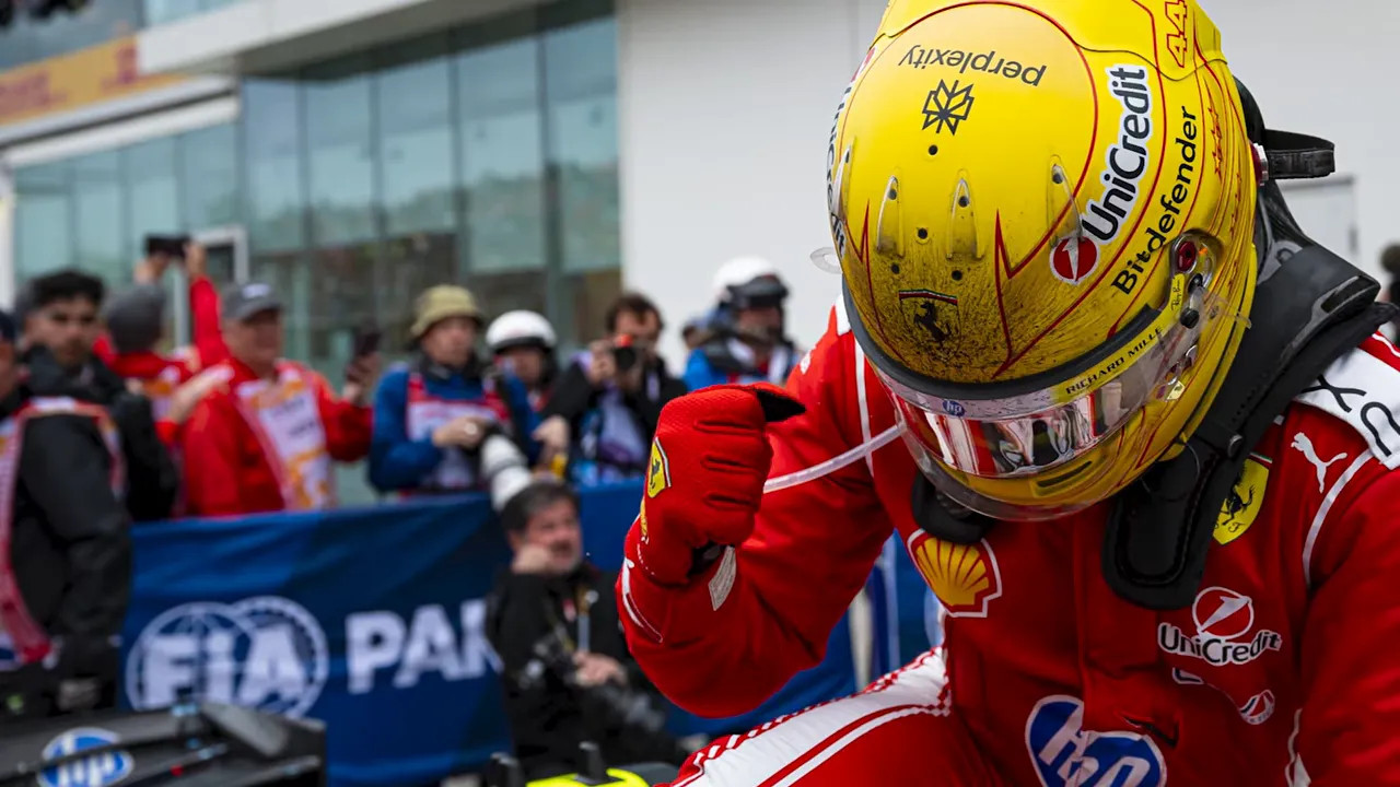 Lewis Hamilton in Ferrari overalls celebrating beside his car in parc ferme
