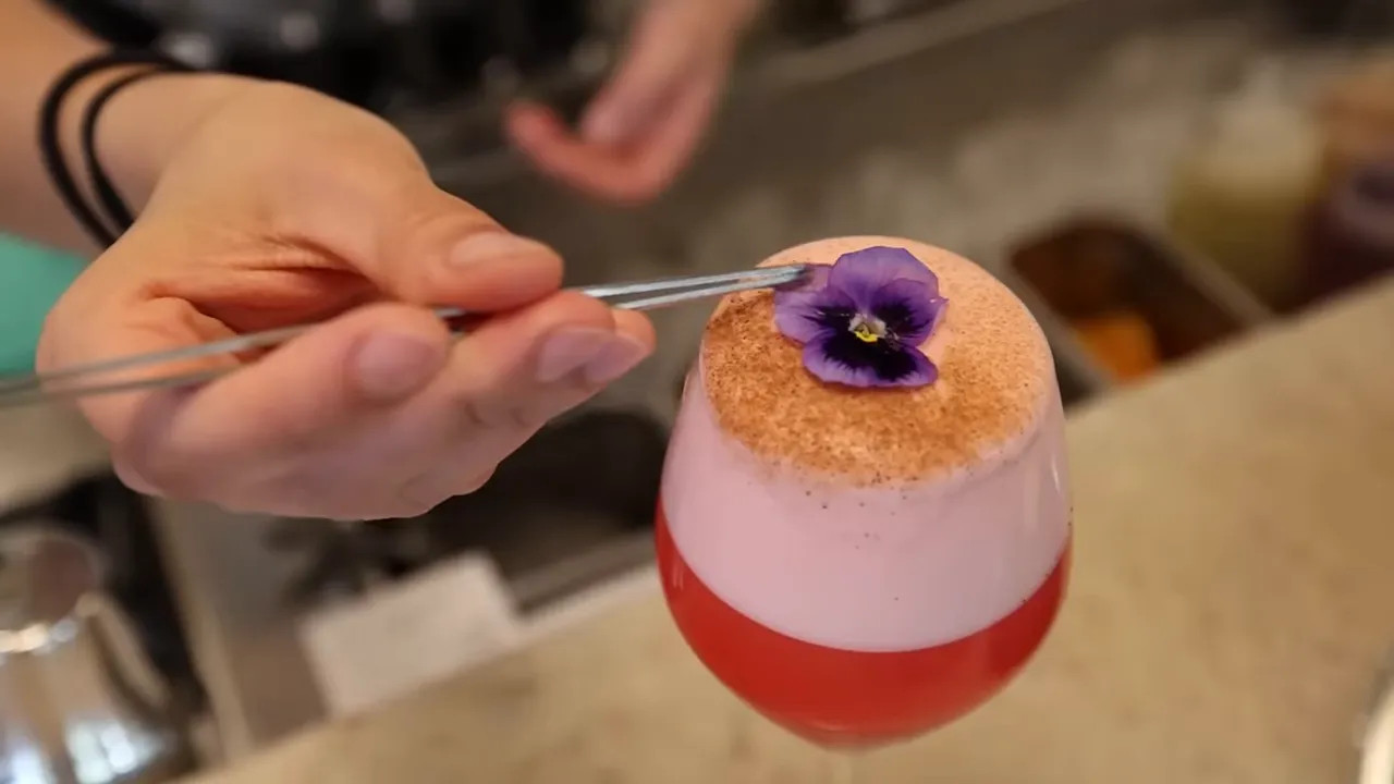 Close-up of a plated cocktail-style dessert with edible flower garnish