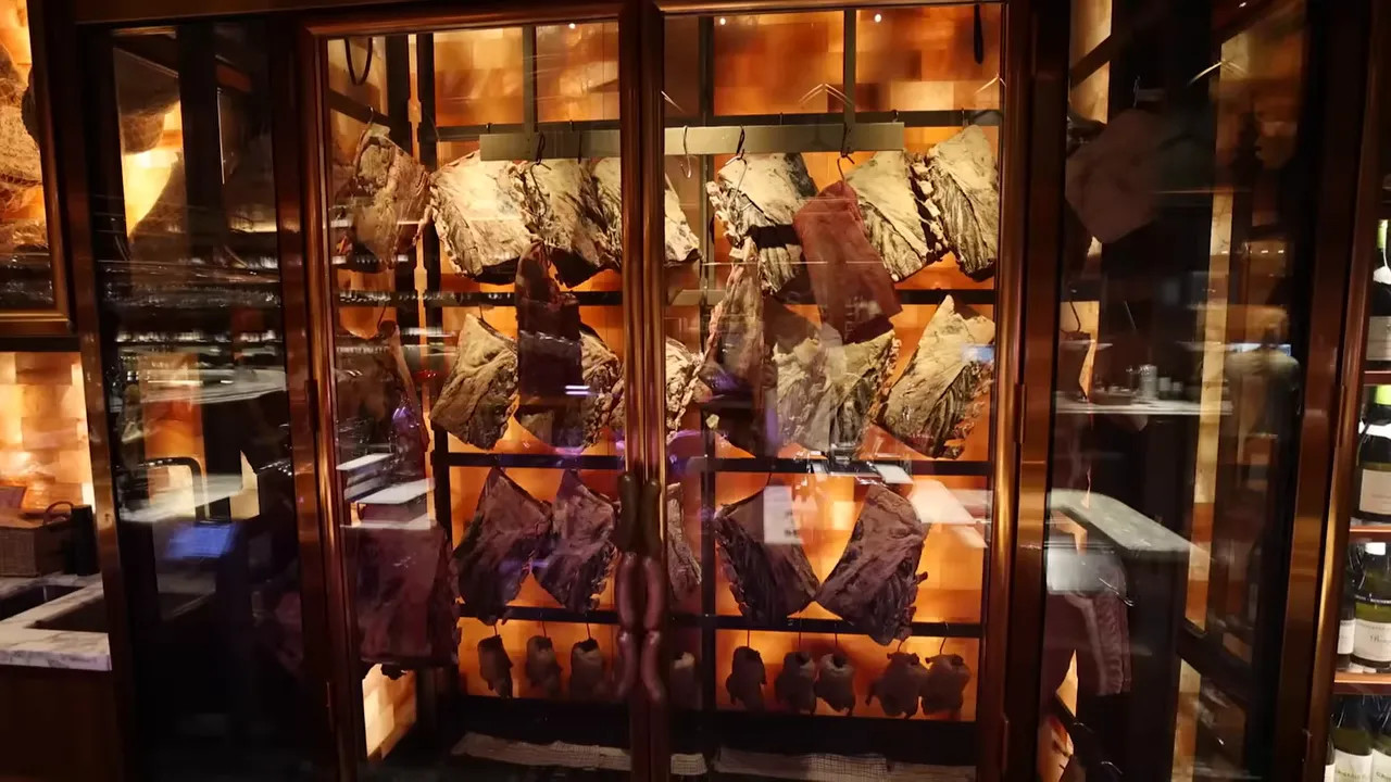 Hanging aged meat cuts in a butcher shop display case