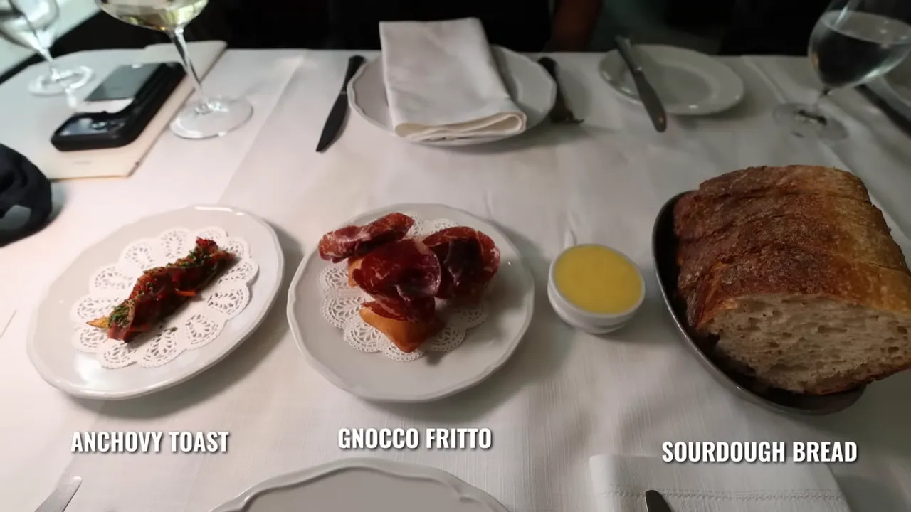 Table spread of sourdough bread, anchovy toast, and gnocco fritto with drinks at Gimlet in Melbourne