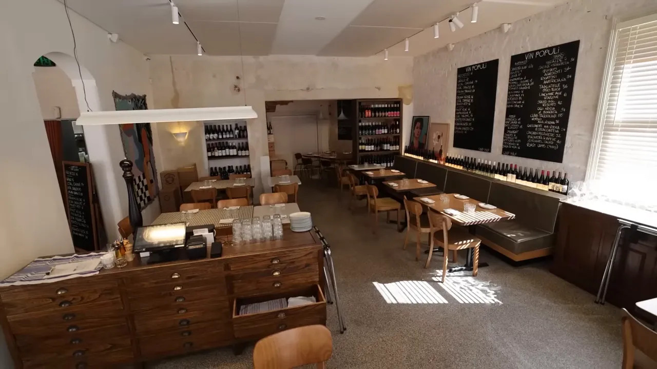 Vin Populi restaurant interior with wine bottles and chalkboard menus on the wall