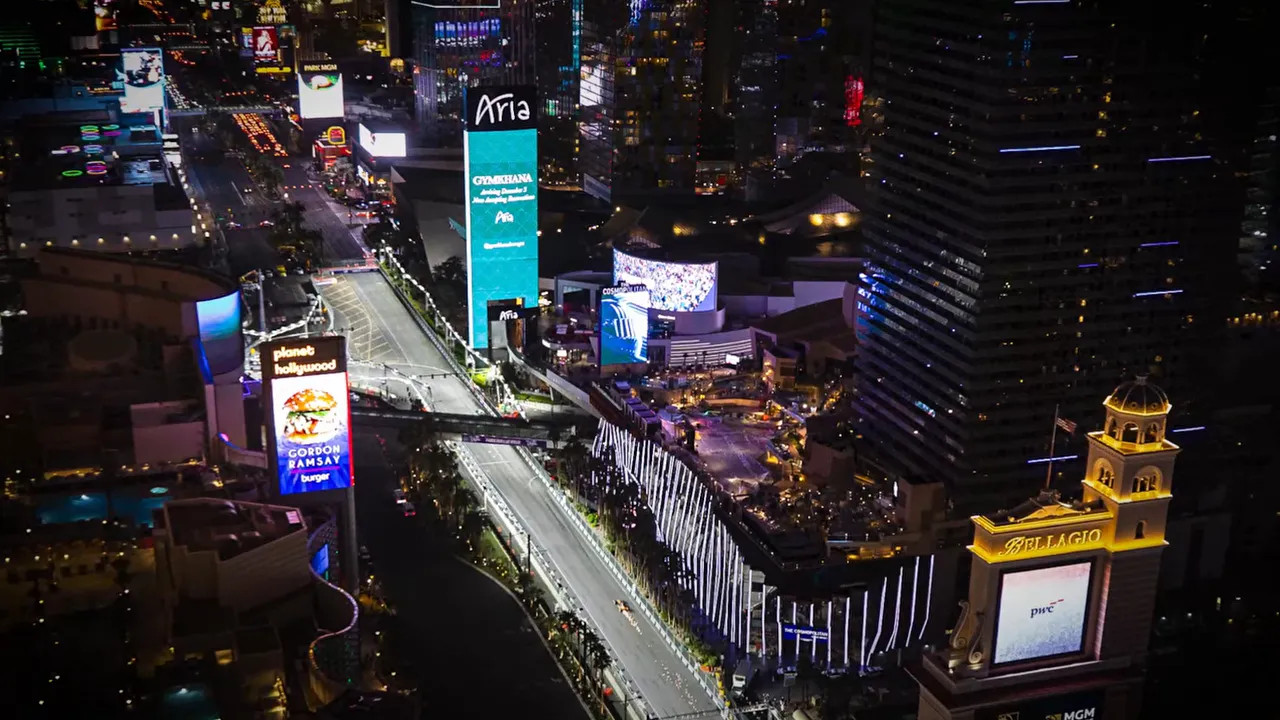 Night aerial view of the Las Vegas Strip with billboards and the Formula 1 event in view