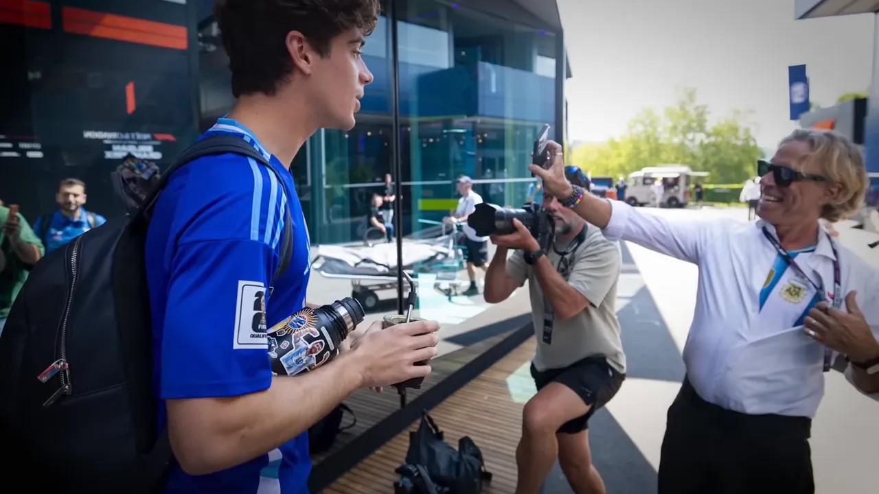 Man holding an Argentina football shirt beside Franco Colapinto in blue