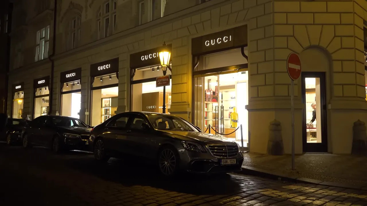 Night exterior of Gucci store with luxury car in front