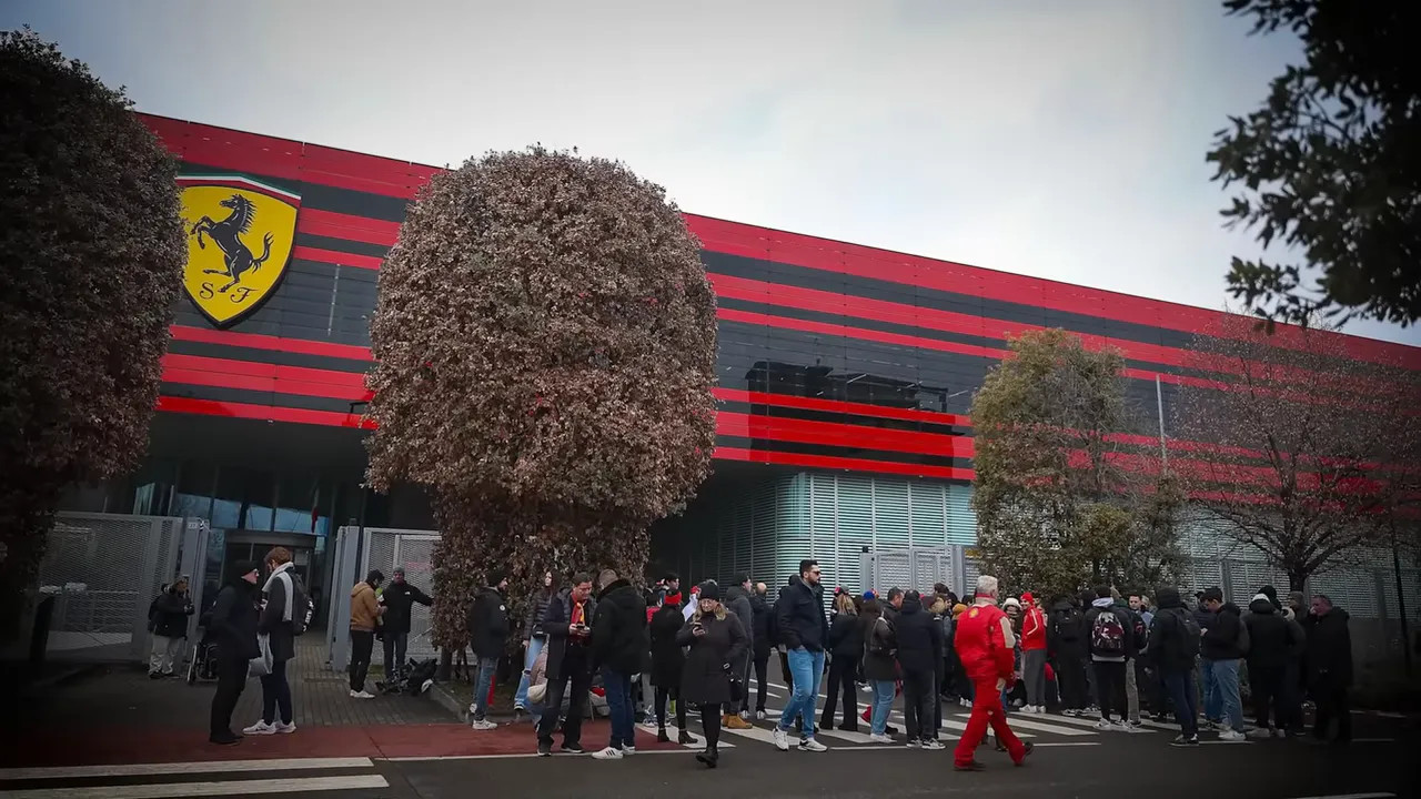 Ferrari team building façade with the prancing horse shield and groups of fans gathered outside