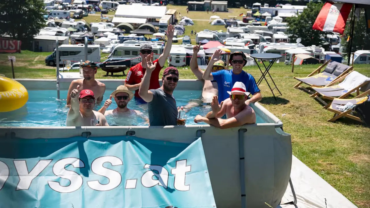 Fans waving from a raised swimming pool at the campsite near the circuit