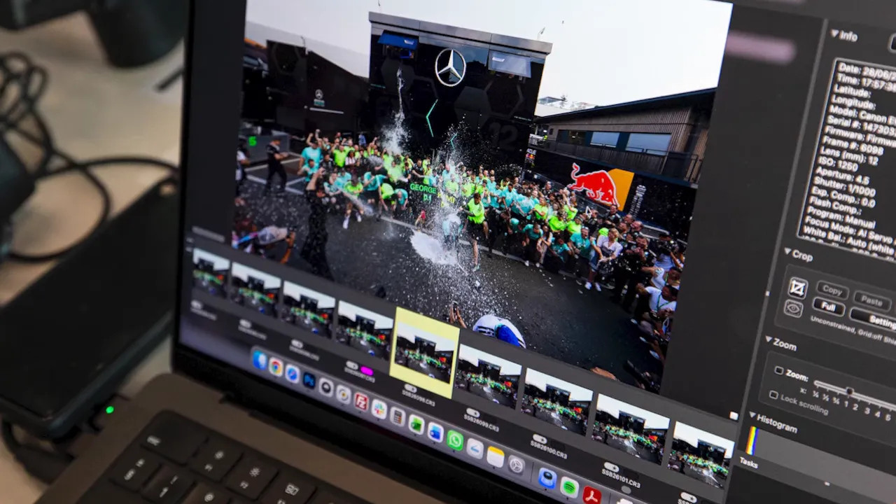 Laptop screen showing photos of the Mercedes team celebration with champagne spraying