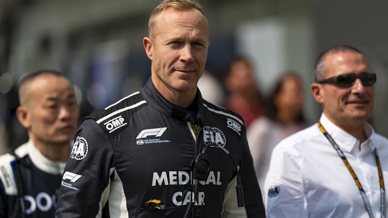 Safety car driver in black FIA medical car uniform with medical car text on screen