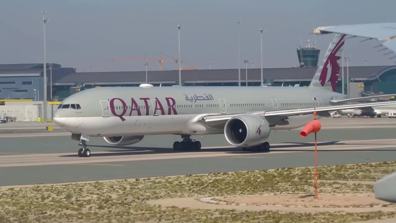 Qatar Airways 777-300ER taxiing at airport with visible Qatar logo
