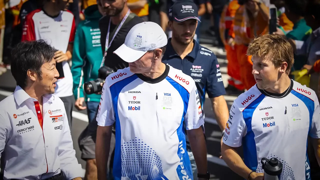 Driver in a team garage receiving attention from engineers
