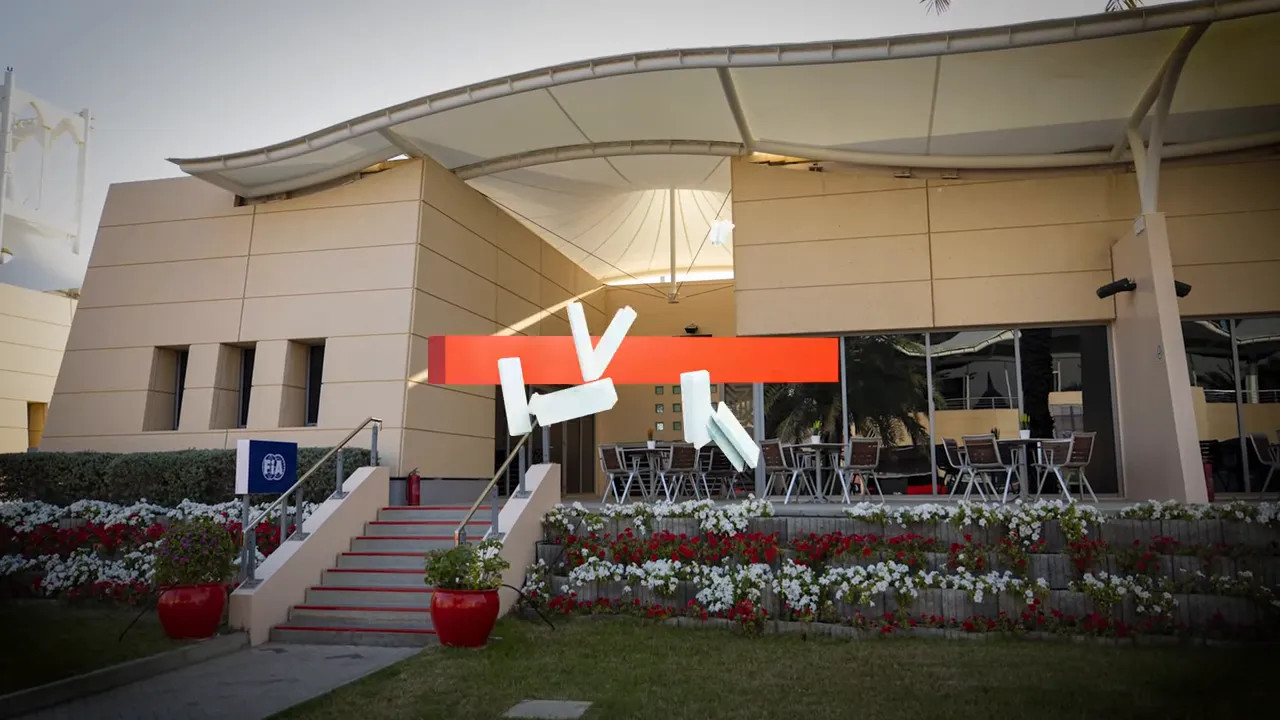 Exterior entrance of an FIA building with seating area and flower beds