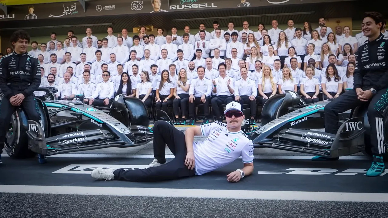 High-resolution Mercedes team group photo with the main team lineup behind two cars