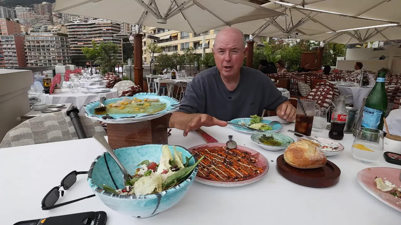 Table set with multiple dishes including salad and grilled items at a harbour view restaurant