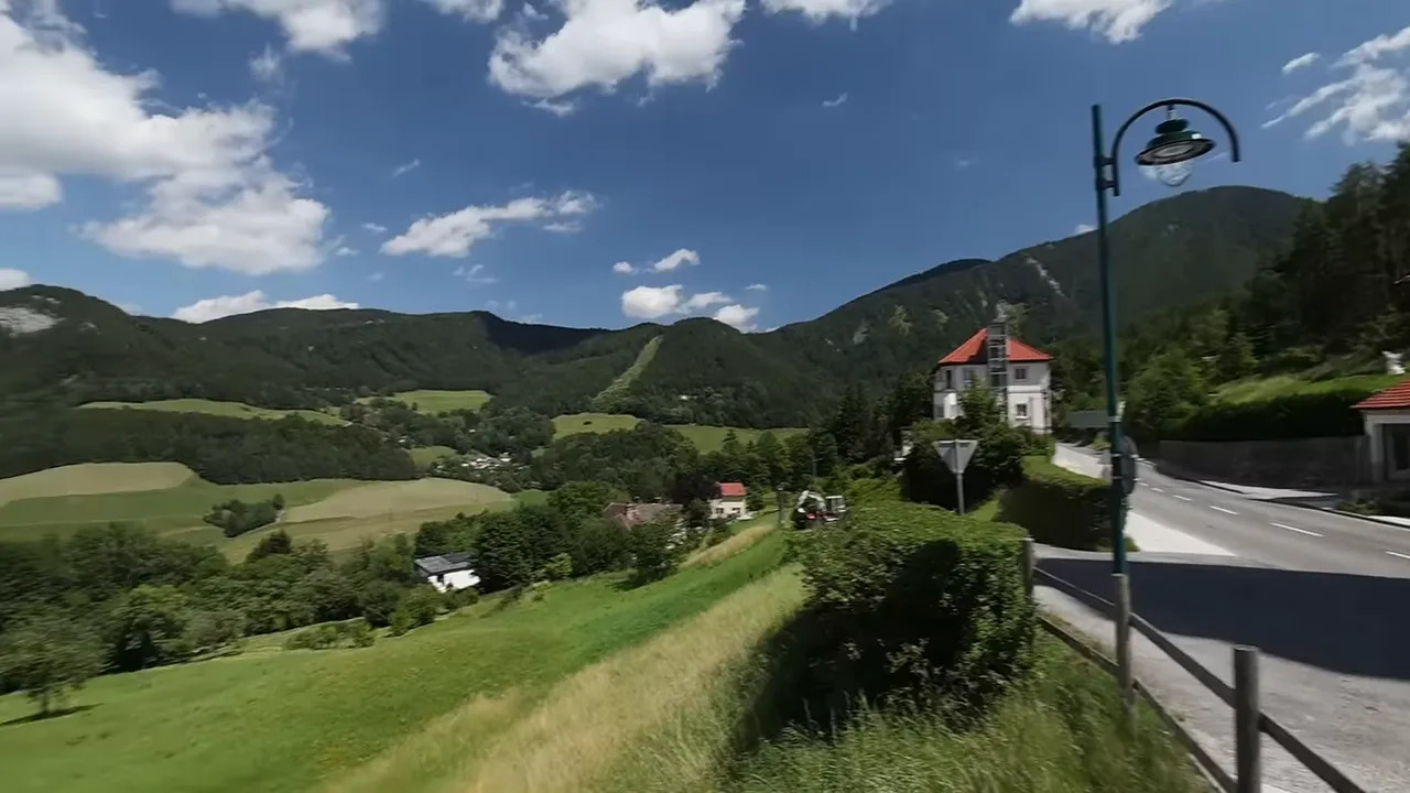 Green valley and forested mountains under a blue sky