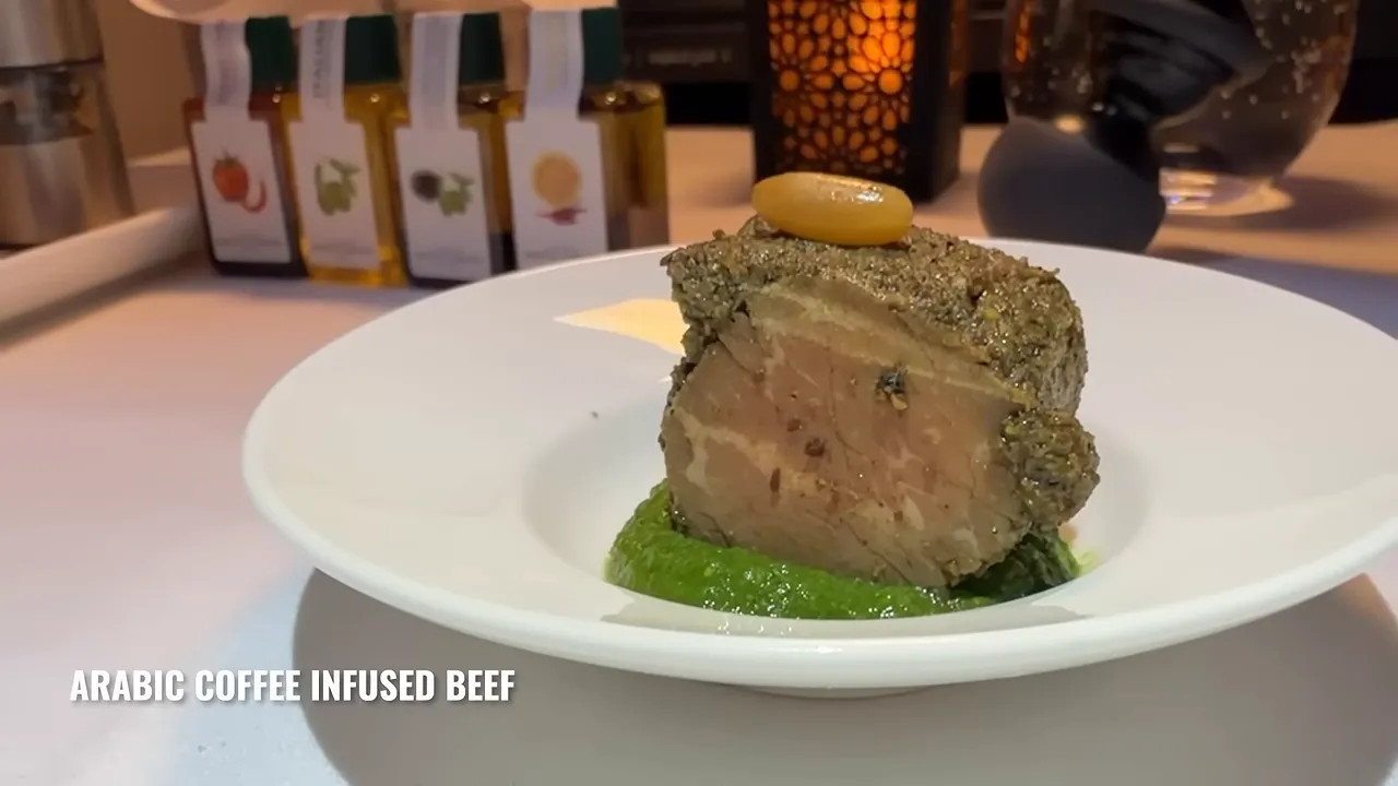 Arabic coffee infused beef served on a white plate with green puree