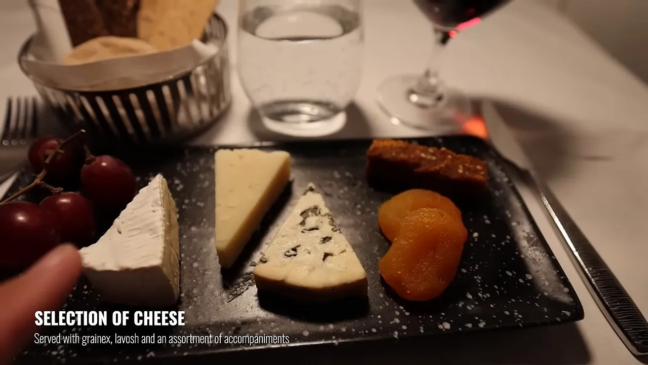 Cheese board with brie blue cheese crackers grapes and dried apricots