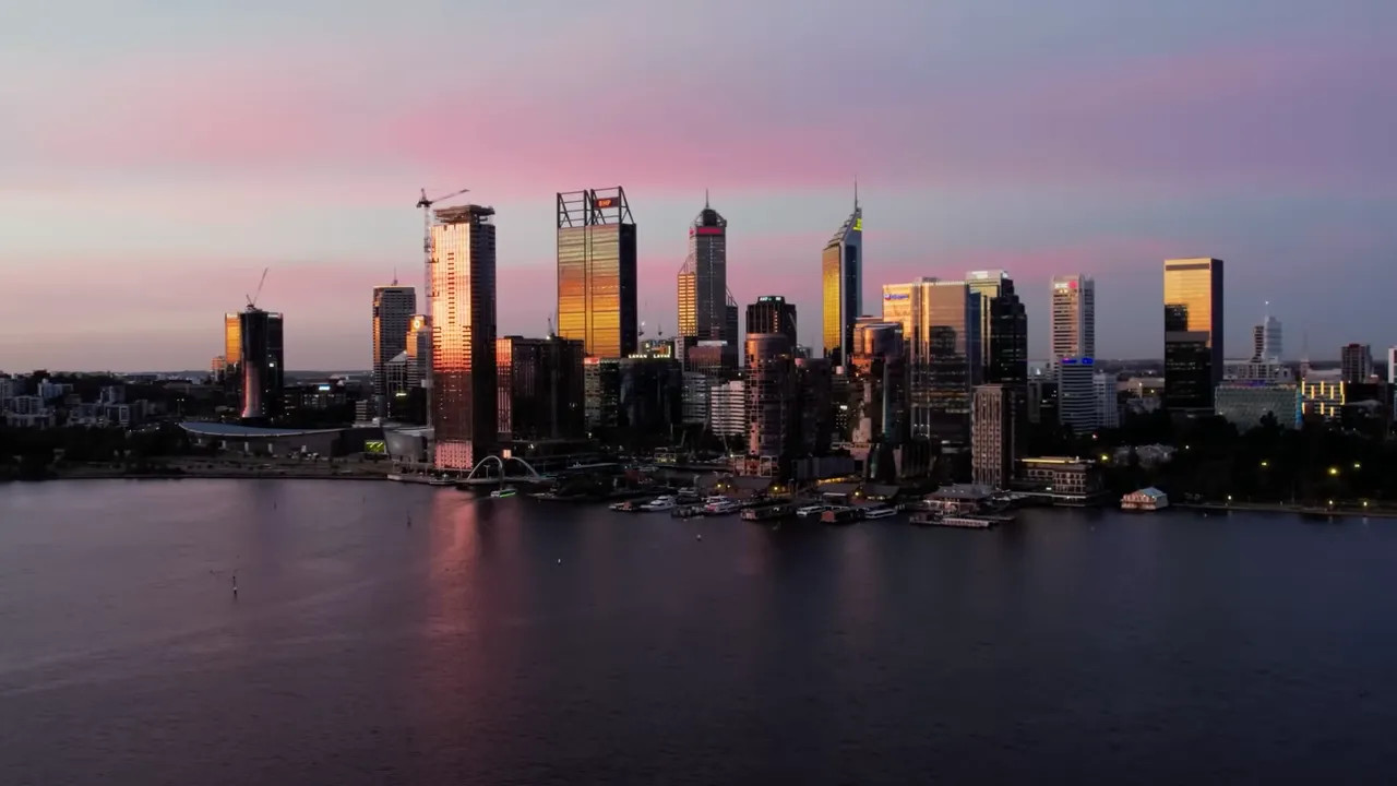 Perth city skyline at sunset with golden reflections on the riverfront buildings