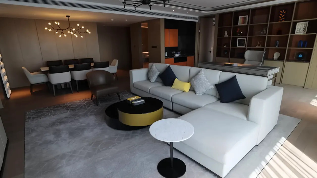 Voco hotel suite living area with sofa, coffee table and dining area