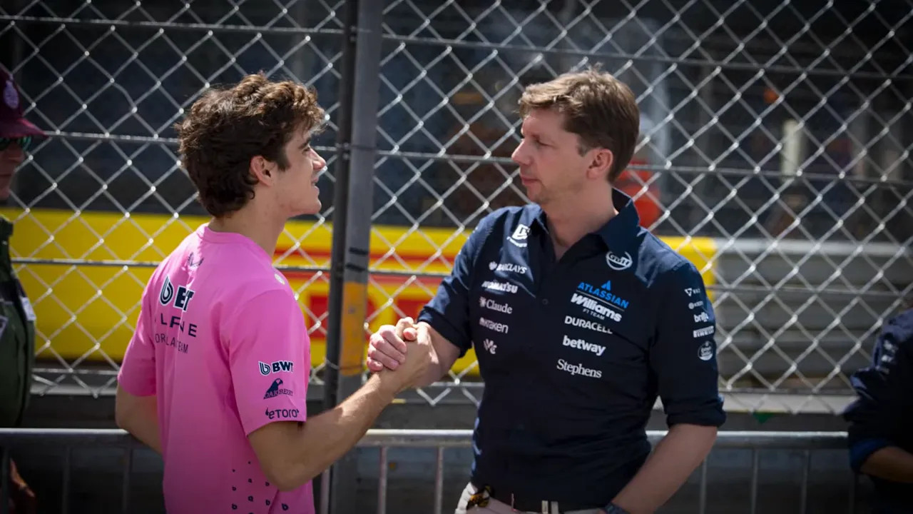 Franco Colapinto speaking with Williams team principal James Vowles beside a fence