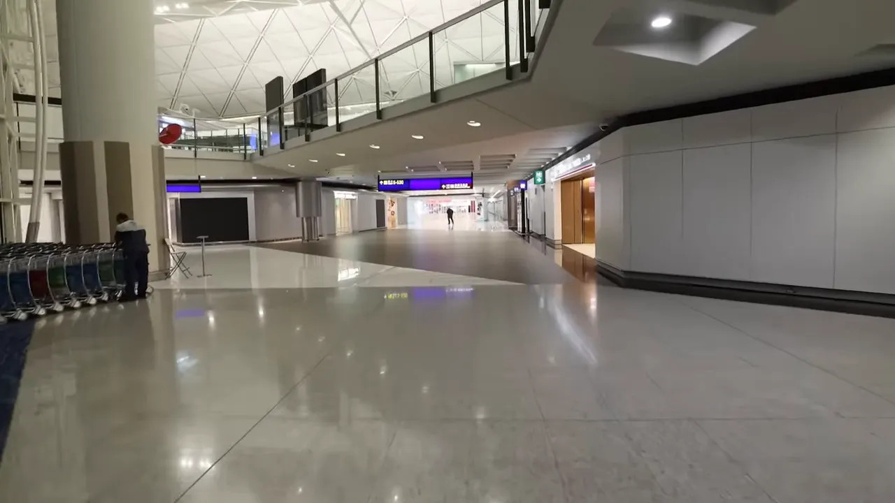 Empty airport terminal corridor with flight information screens during a China visa run