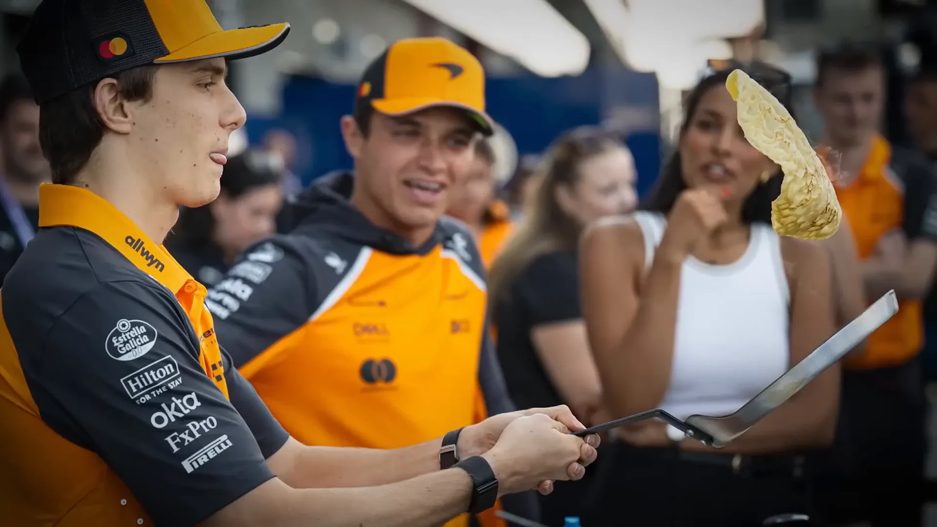 Oscar Piastri and Lando Norris flipping pancakes in the paddock