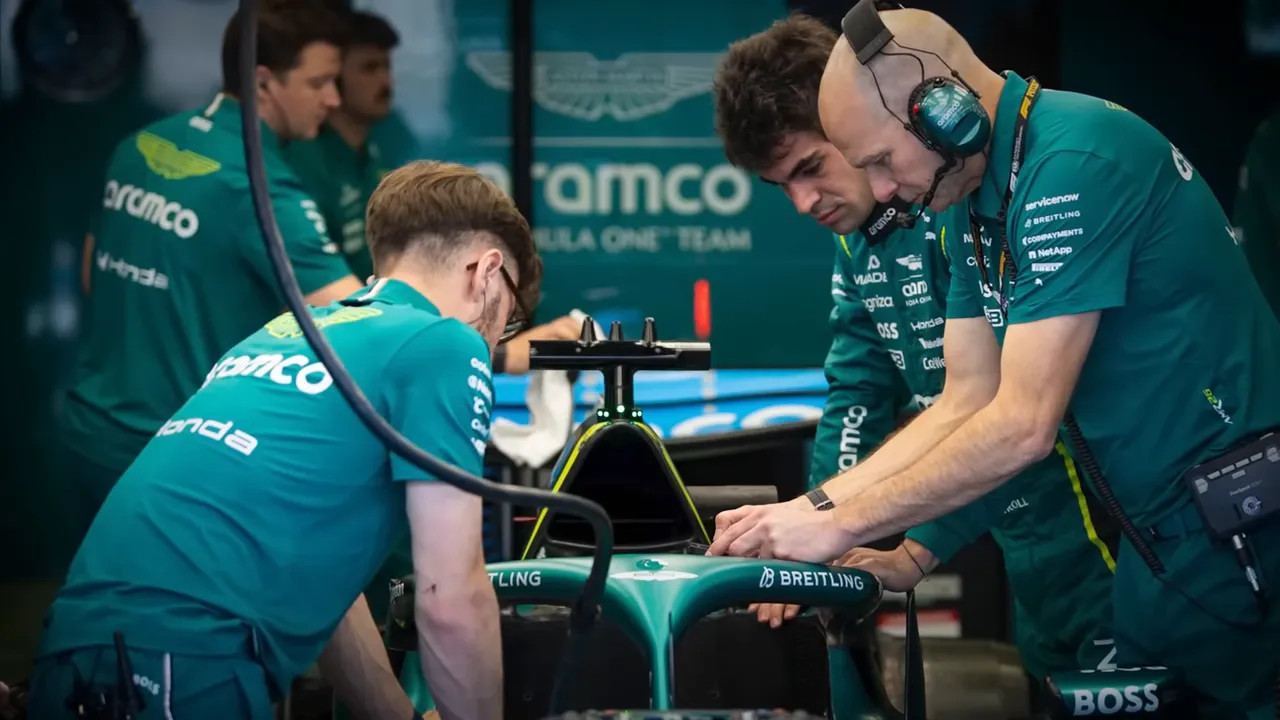 Aston Martin mechanics and engineers leaning over the car's nosecone making adjustments in the garage
