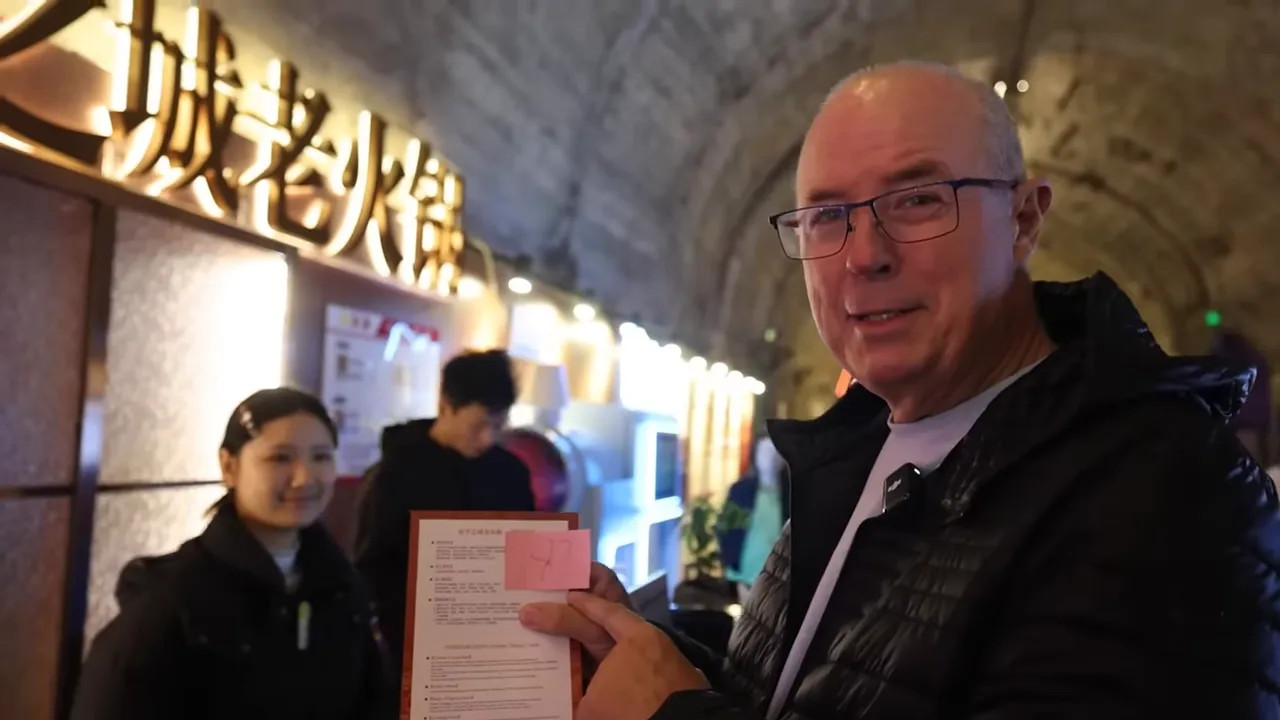 Visitor holding a hot pot menu inside a tunnel restaurant in Chongqing