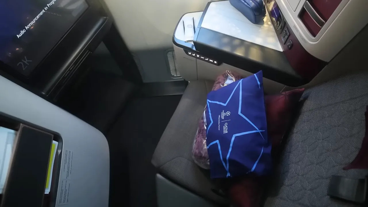 Cabin seat area with a Qatar Airways amenity bag in the seat pocket