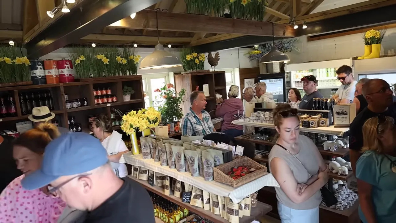 Crowded interior of Diddly Squat Farm Shop with shelves of produce and customers filling the room