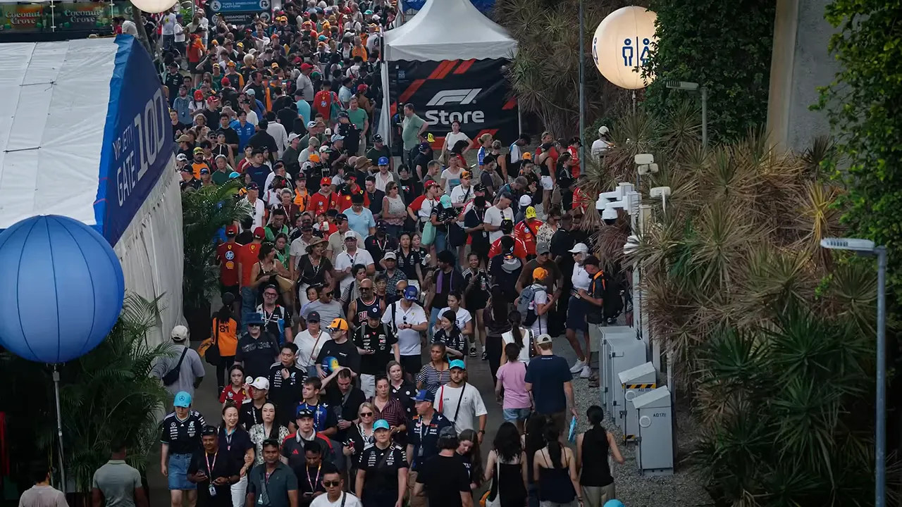 A dense crowd filling a walkway beside Singapore Grand Prix facilities