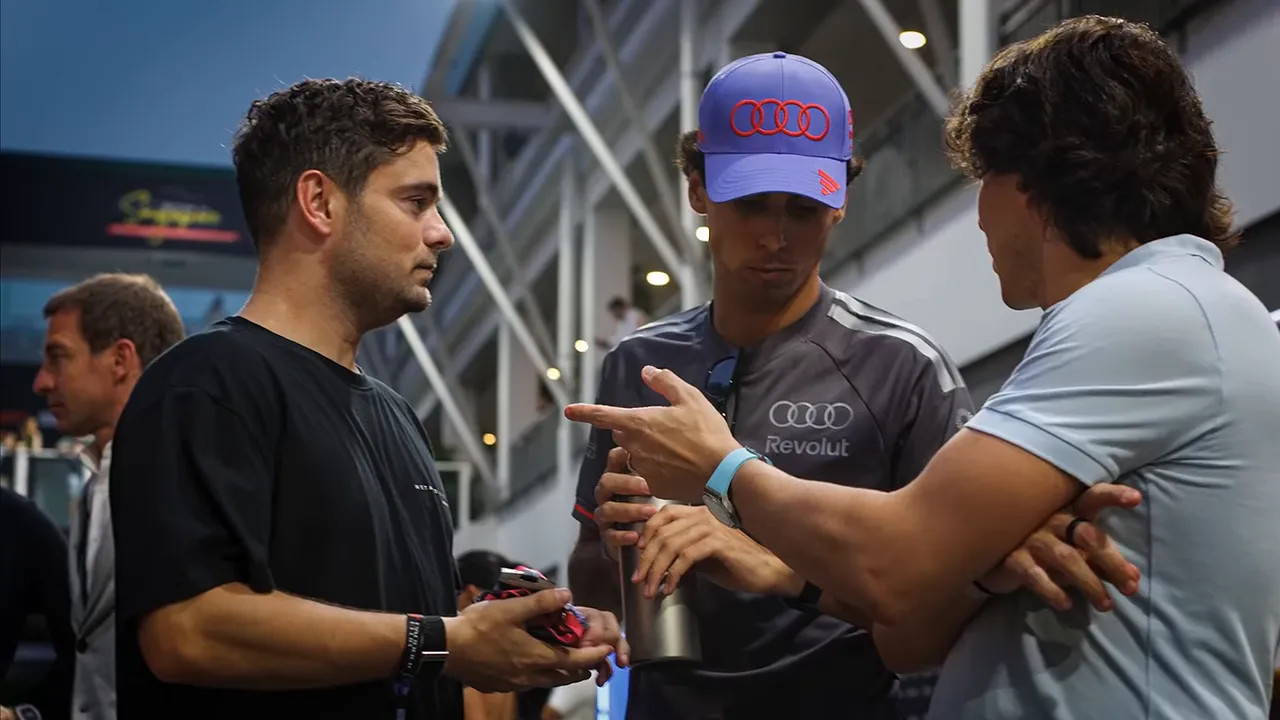 Martin Garrix and Gabriel Bortoleto talking with another man in the paddock
