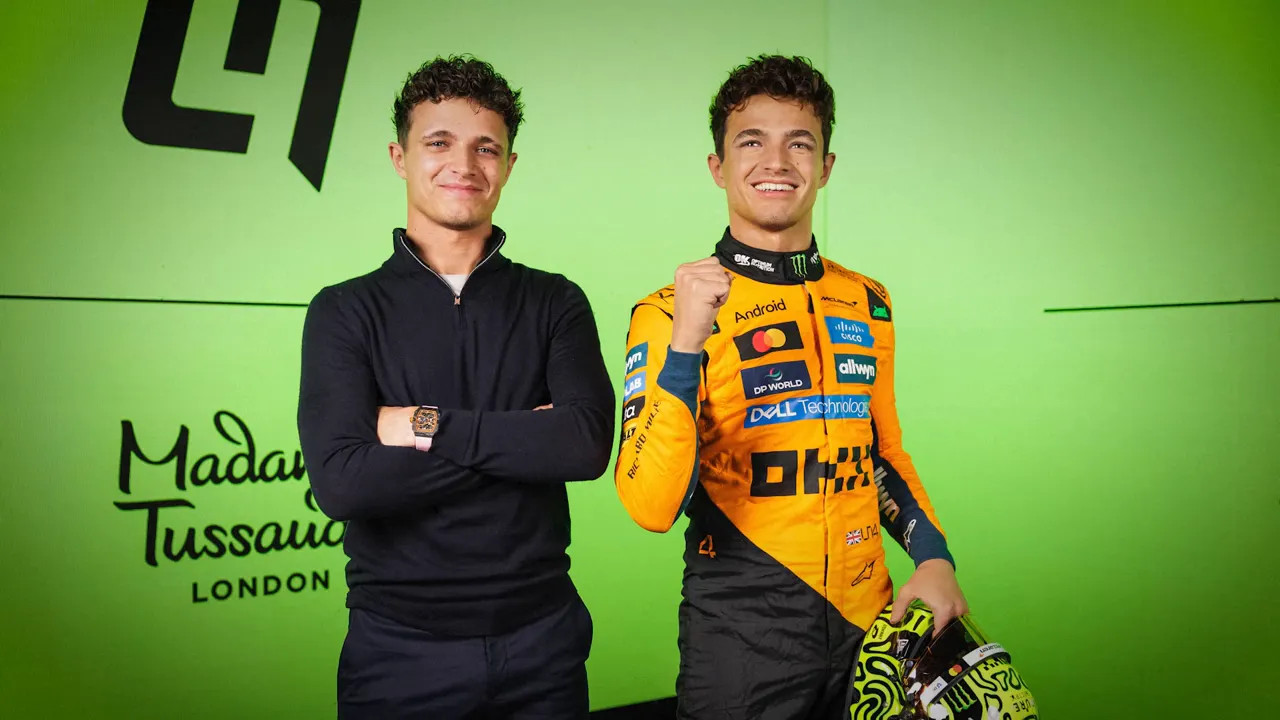 Lando Norris standing beside his Madame Tussauds figure against a bright green backdrop
