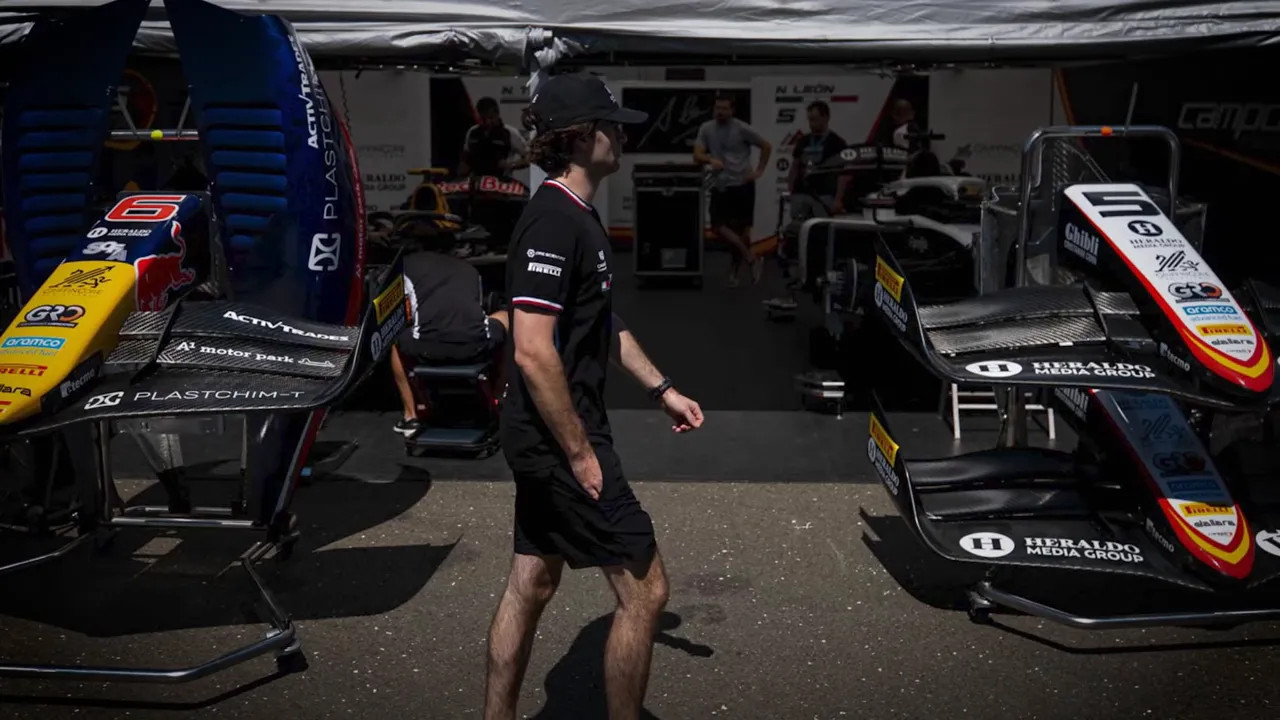 Nikola Tsolov standing beside a Formula 2 car inside the Campos garage