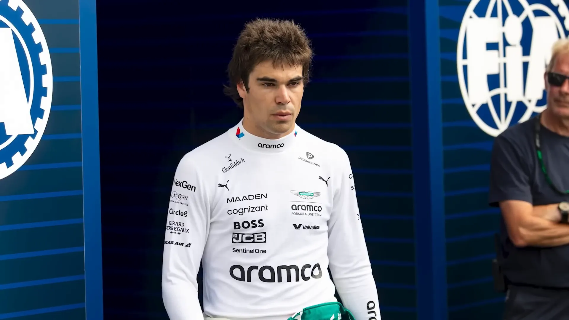 Lance Stroll discussing his injury with team officials.