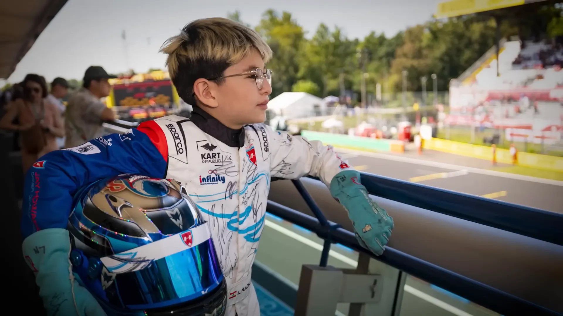 Young fan in a race suit collecting driver signatures at Monza